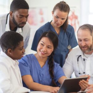 group of medical professionals looking at a laptop