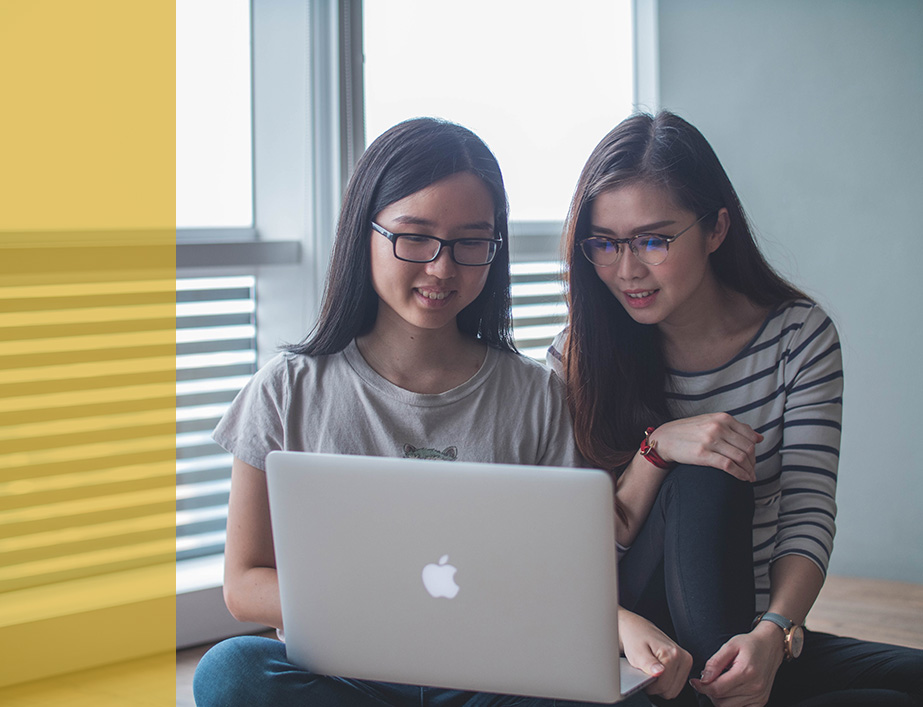 two people smiling at a computer